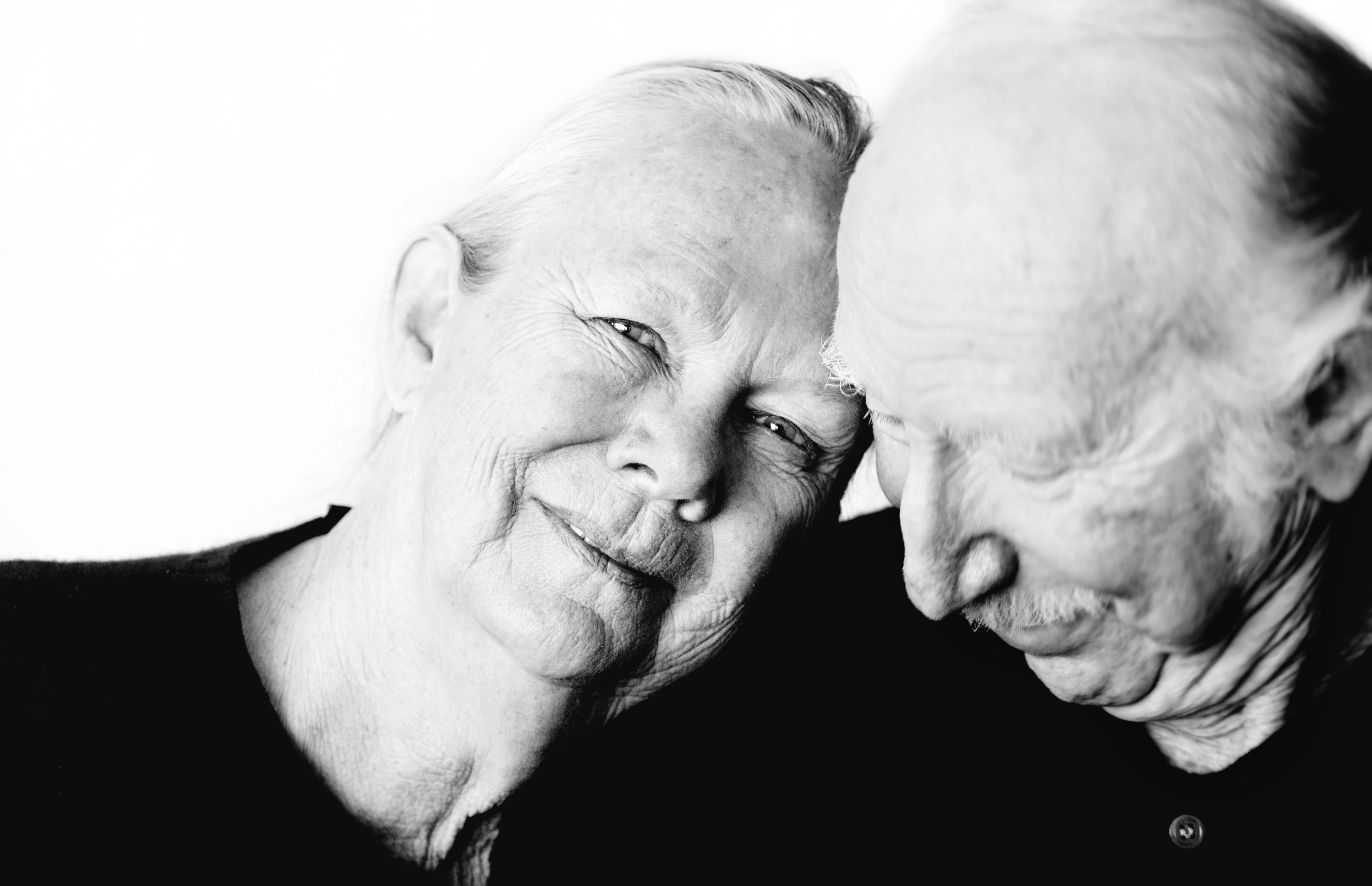 older couple with heads touching and smiling