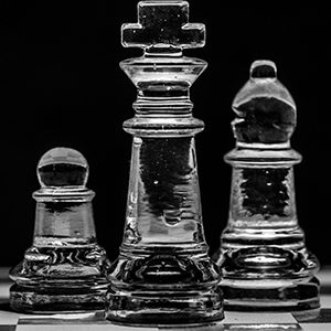 Clear Chess Set on a Black Background with a Checkboard floor